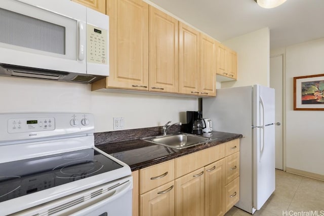 kitchen featuring a sink, white appliances, dark countertops, and light brown cabinets