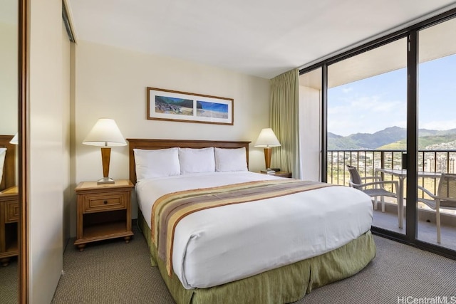 carpeted bedroom featuring access to exterior, a mountain view, and expansive windows