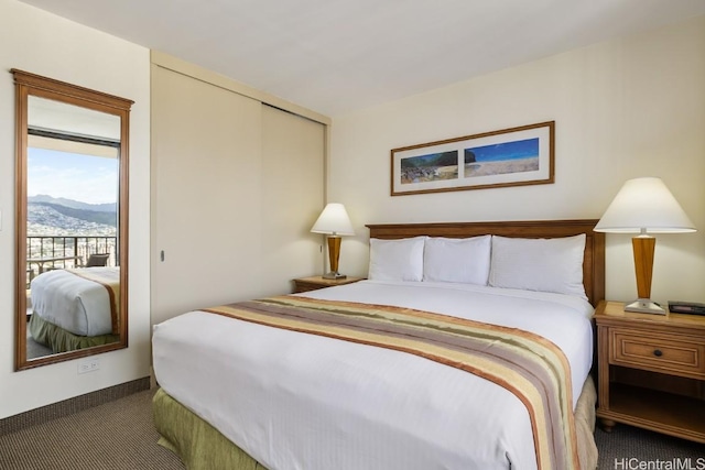 carpeted bedroom featuring a closet, a mountain view, and access to outside