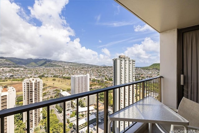 balcony with a mountain view and a city view