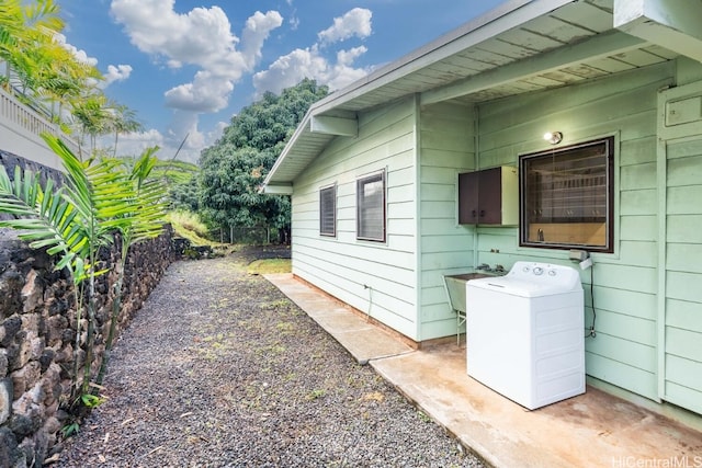 view of home's exterior with washer / clothes dryer and a sink