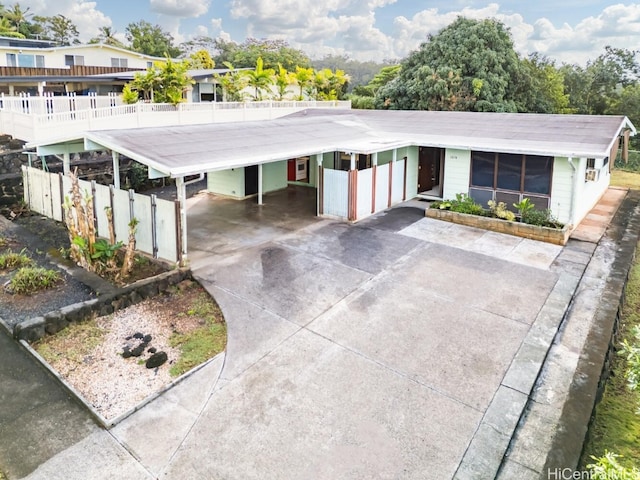 view of front of home featuring an attached carport, driveway, and fence