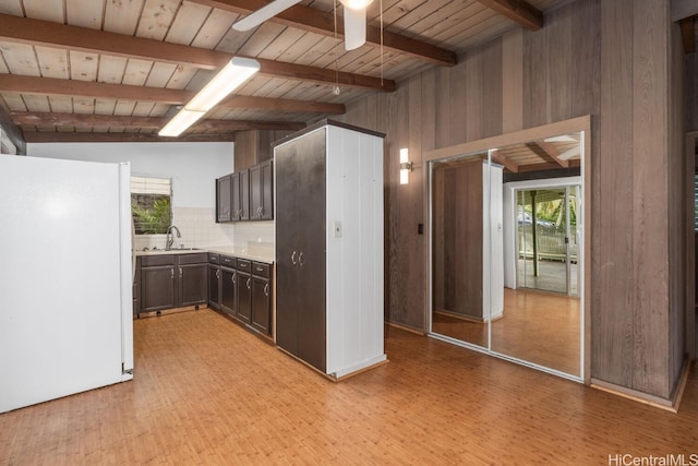 kitchen featuring dark brown cabinets, ceiling fan, light countertops, freestanding refrigerator, and a sink