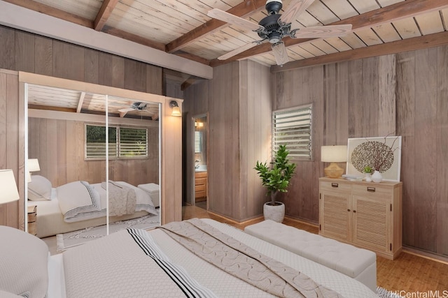 bedroom with wooden walls, beamed ceiling, wood ceiling, and wood finished floors