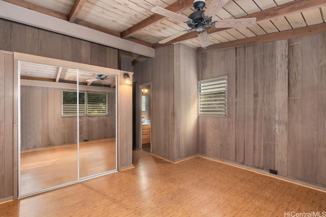 unfurnished bedroom featuring beamed ceiling, wood finished floors, wood walls, and wooden ceiling