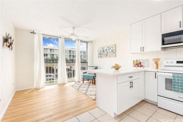 kitchen with ceiling fan, light countertops, white cabinetry, light wood-type flooring, and white range with electric stovetop