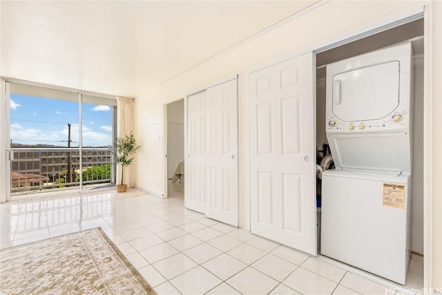 washroom featuring light tile patterned floors, laundry area, and stacked washer and clothes dryer