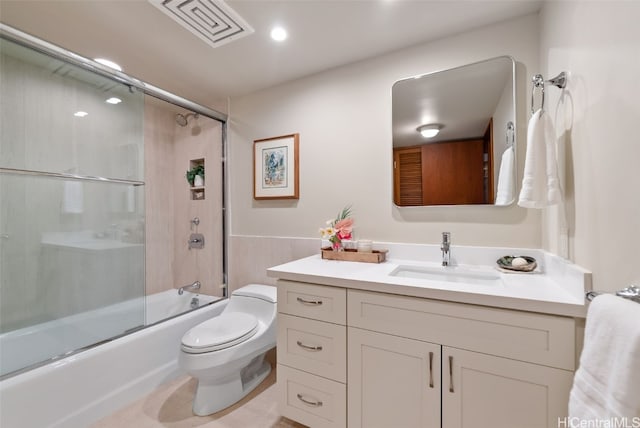 full bathroom featuring toilet, combined bath / shower with glass door, vanity, and visible vents