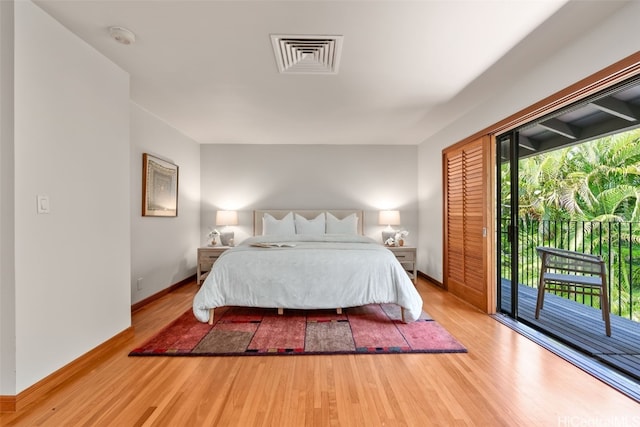 bedroom with access to outside, multiple windows, visible vents, and wood finished floors