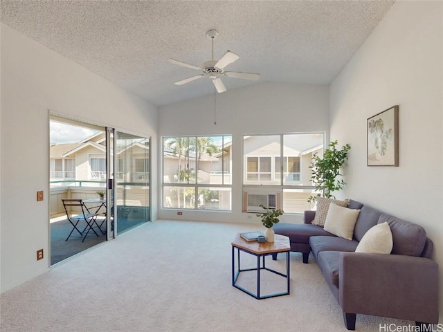 living room featuring lofted ceiling, carpet, ceiling fan, and a textured ceiling