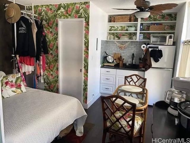 bedroom featuring freestanding refrigerator and a toaster