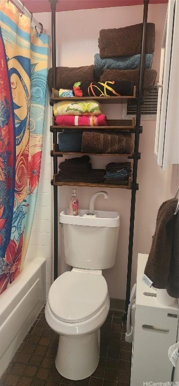 full bath featuring toilet, tile patterned flooring, and shower / bath combo with shower curtain