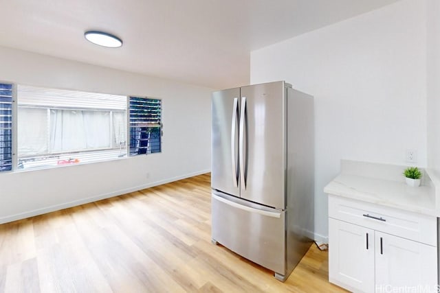 84-562 Nukea St, Waianae, HI 96792 - kitchen featuring freestanding refrigerator, white cabinetry, light wood-style floors, and light stone counters