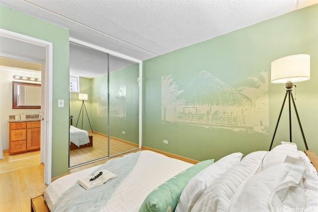 bedroom featuring a closet, light wood finished floors, and a textured ceiling