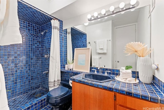 full bathroom with toilet, tiled shower, and vanity