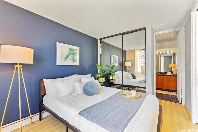 bedroom with a closet, a textured ceiling, and wood finished floors