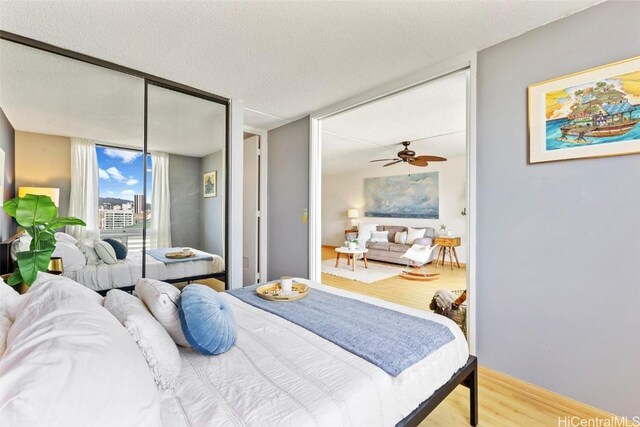 bedroom featuring a textured ceiling, a wall of windows, and wood finished floors