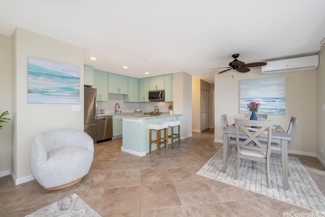 kitchen featuring a breakfast bar area, a wall mounted AC, a peninsula, stainless steel appliances, and light countertops