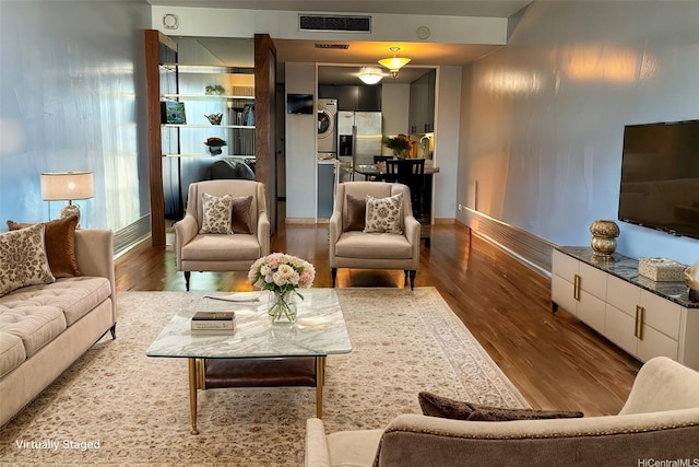 700 Richards St Unit 2403, Honolulu, HI 96813 - living room featuring baseboards, wood finished floors, visible vents, and stacked washing maching and dryer