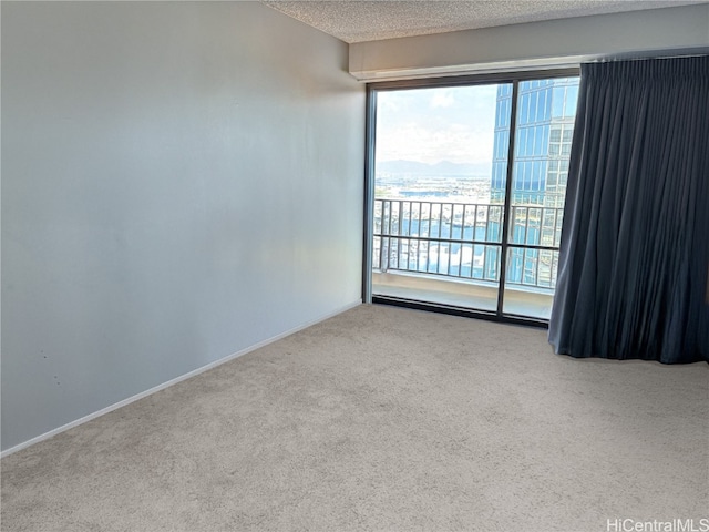 empty room with baseboards, a textured ceiling, and carpet flooring