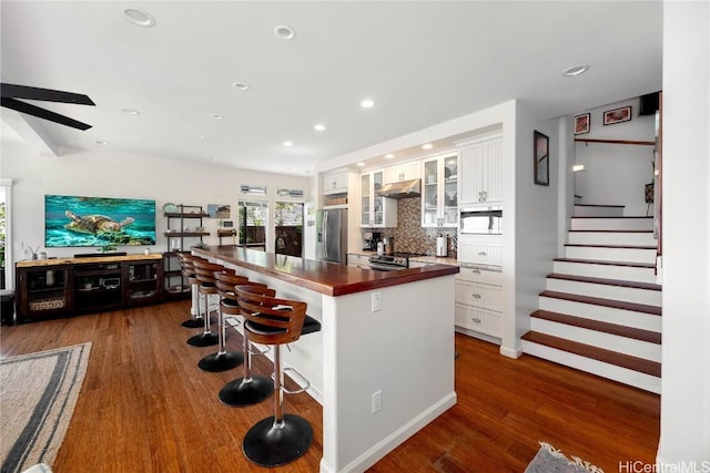 kitchen featuring under cabinet range hood, dark wood-style floors, appliances with stainless steel finishes, and white cabinets