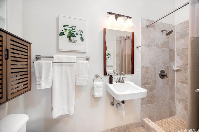 bathroom featuring toilet and tiled shower