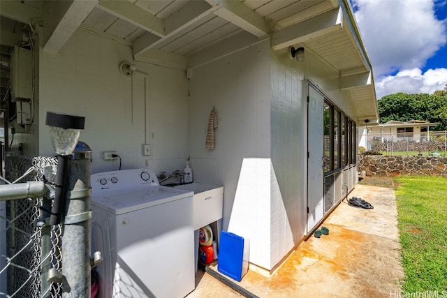 laundry area with laundry area, washer / clothes dryer, and a sink