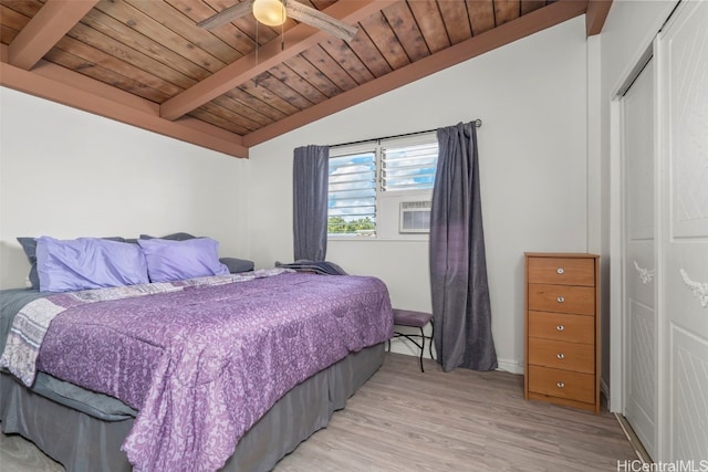 bedroom with lofted ceiling with beams, light wood finished floors, a closet, and wooden ceiling