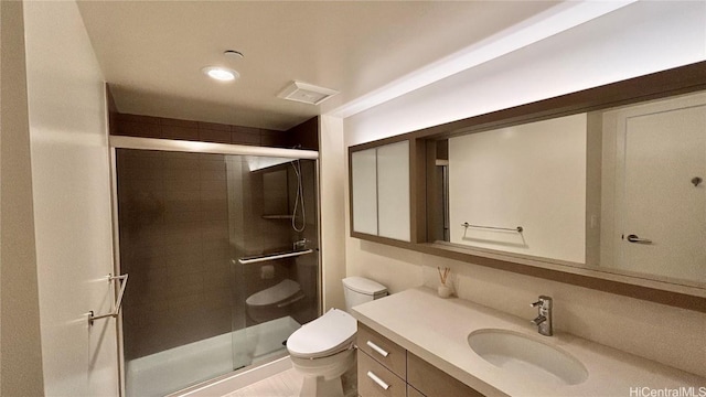 bathroom featuring visible vents, a stall shower, vanity, and toilet