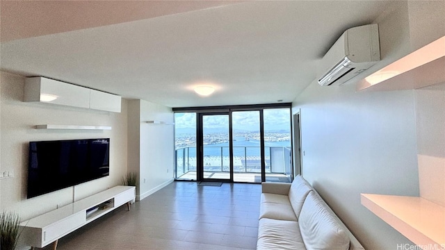 living room with an AC wall unit, a wall of windows, wood finished floors, and baseboards