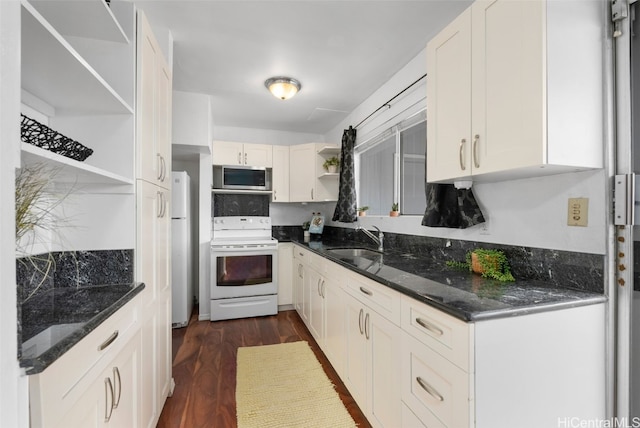 kitchen featuring white appliances, white cabinets, dark wood-style floors, open shelves, and a sink