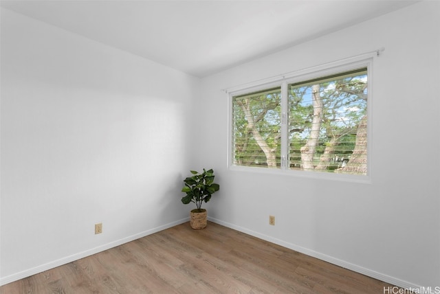 unfurnished room with baseboards and wood finished floors