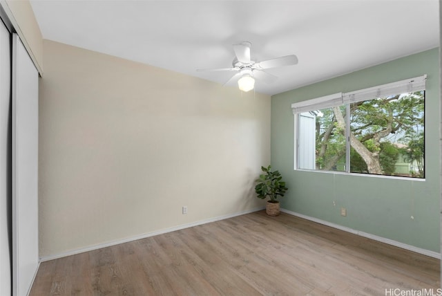 unfurnished bedroom with ceiling fan, a closet, light wood-style flooring, and baseboards