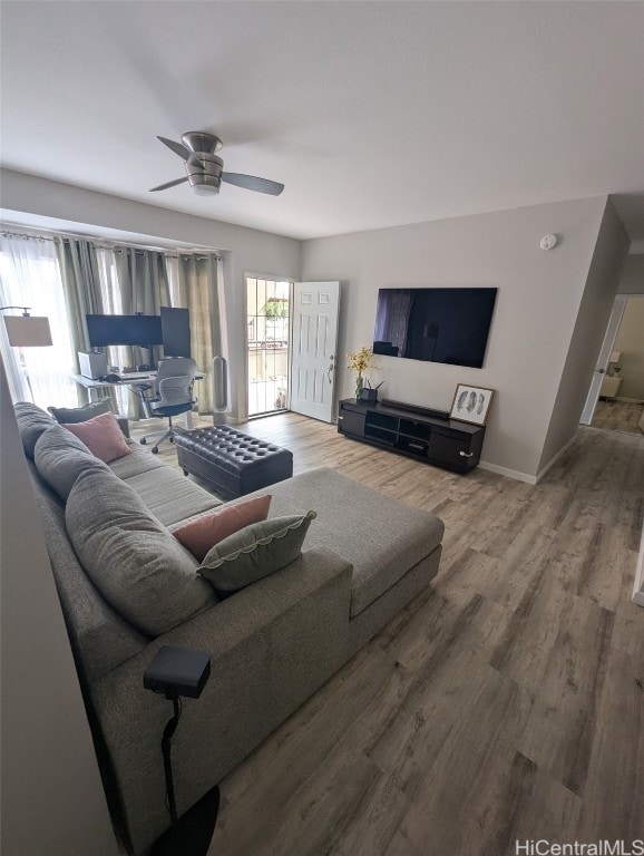 living room with ceiling fan, wood finished floors, and baseboards