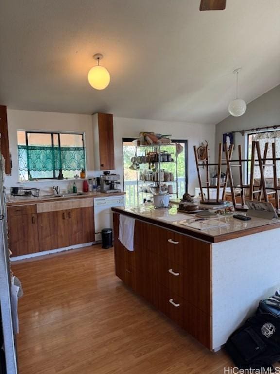 kitchen featuring light wood-style floors, plenty of natural light, white dishwasher, and a center island