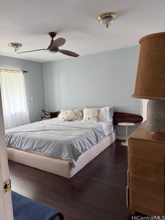 bedroom with ceiling fan and dark wood finished floors