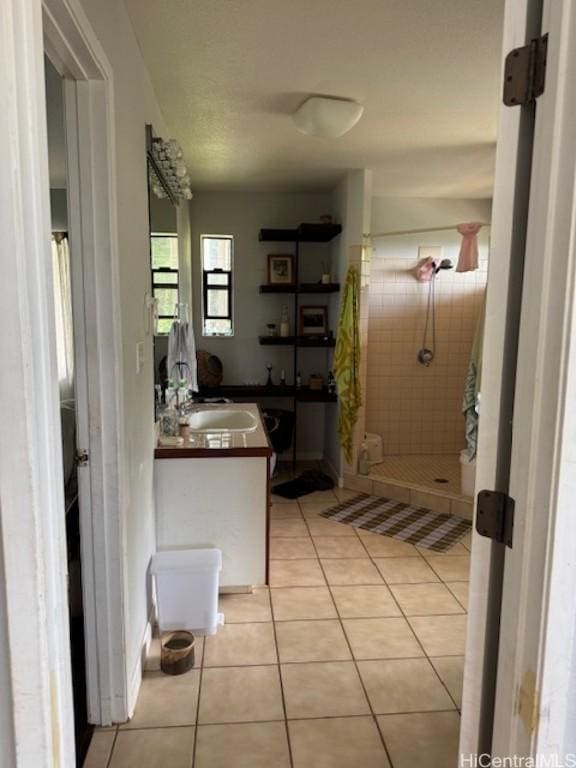 bathroom with a stall shower, tile patterned flooring, and vanity