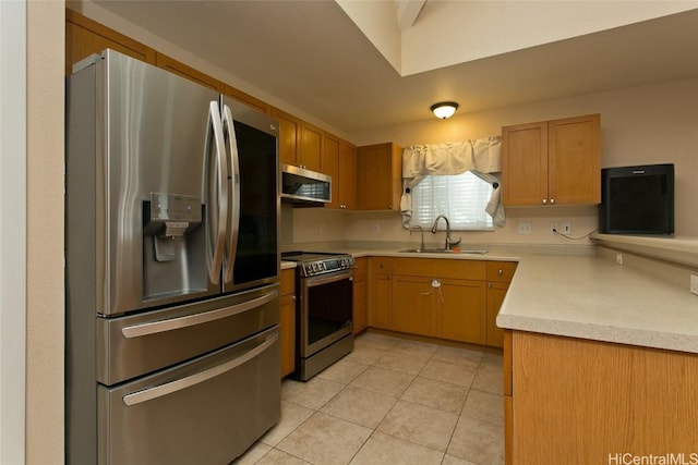 kitchen featuring light tile patterned floors, stainless steel appliances, a sink, and light countertops