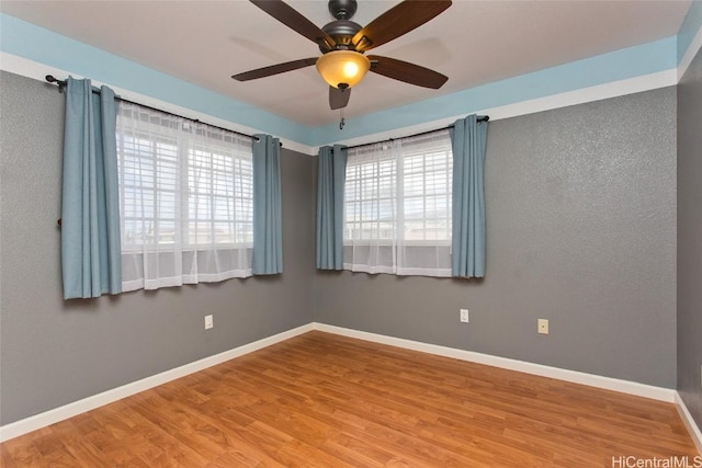 empty room with baseboards and wood finished floors