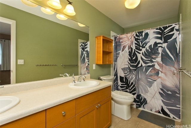 bathroom with double vanity, tile patterned flooring, a sink, and toilet