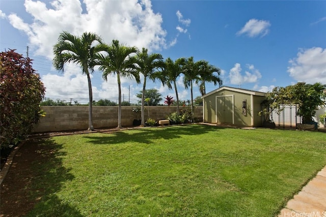 view of yard with a fenced backyard, a storage unit, and an outdoor structure