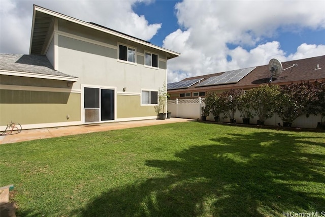 rear view of house featuring a lawn, a patio area, fence, and stucco siding