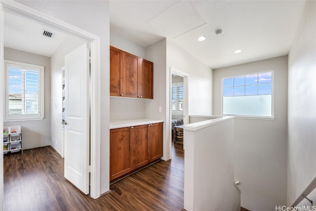 kitchen featuring recessed lighting, light countertops, visible vents, dark wood-type flooring, and brown cabinetry