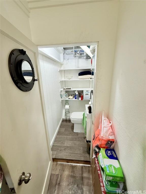 bathroom with wood finished floors, toilet, and baseboards