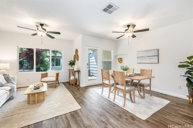 dining space with visible vents, baseboards, dark wood-type flooring, and a ceiling fan