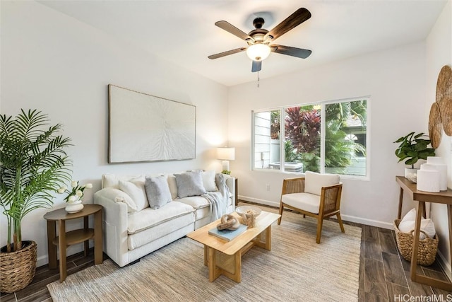 living room with ceiling fan, baseboards, and wood finished floors