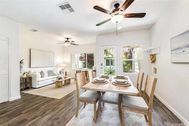 dining area featuring dark wood finished floors, baseboards, and visible vents