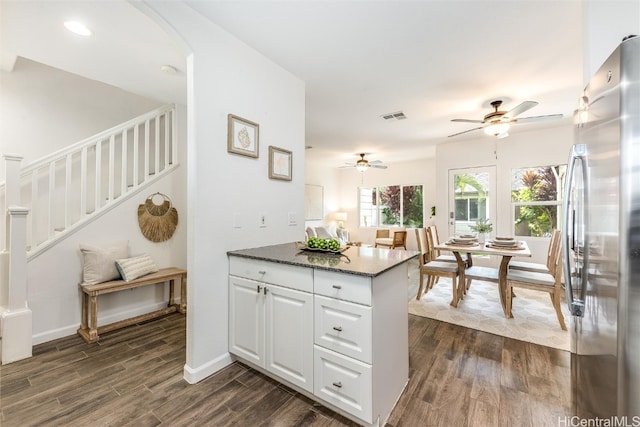 kitchen with white cabinetry, dark wood-style floors, visible vents, and stainless steel fridge