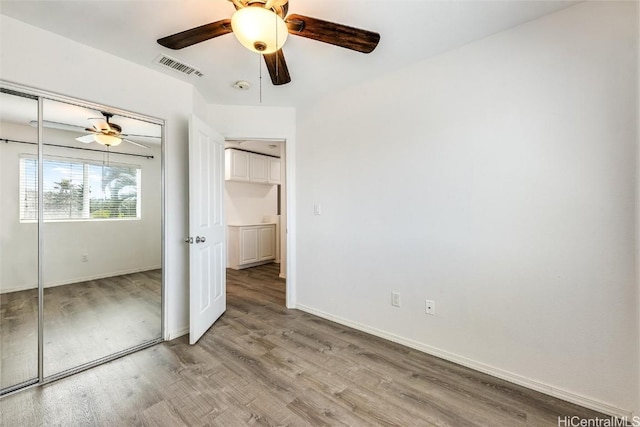 unfurnished bedroom with light wood finished floors, visible vents, a closet, and baseboards