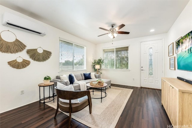 living area with dark wood finished floors, a wall unit AC, recessed lighting, and a ceiling fan